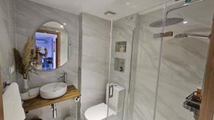 a bathroom with a shower and a sink and a mirror at Apartmento de 3 habitaciones con vistas al mar in Playa de Gandia