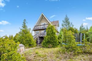 una casa vieja en una colina con árboles en Dragonfly Cove - Nature-inspired Lakeside Living, en Tobermory