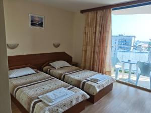 a hotel room with two beds and a balcony at Hotel Shipka Beach in Sunny Beach +101 photos