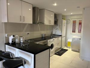 a kitchen with white cabinets and a washer and dryer at Apartmento de 3 habitaciones con vistas al mar in Playa de Gandia +17 photos
