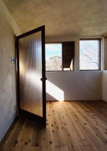 une chambre vide avec une porte et une fenêtre dans l'établissement Private Forest Cottage for Two, Organic Lifestyle, à Bungoono