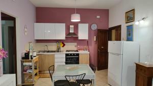 a kitchen with a table and a white refrigerator at Casa Fiorello in Città della Pieve