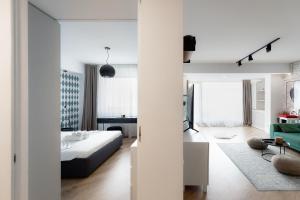 a white bedroom with a bed and a living room at Jade I Family 1&2 BR Apartments near Pipera Plaza Mall in Voluntari +66 photos