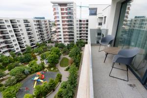 an apartment balcony with a view of a park at City One I One Bedroom Apartment near Pipera Plaza Mall in Voluntari +66 photos