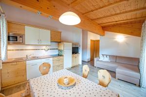 a kitchen and living room with a table and chairs at Apartments DAMONT in Santa Cristina Gherdëina