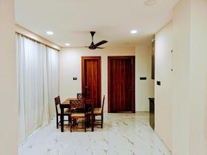 a dining room with a table and chairs and a ceiling fan at Olive Retreat in Guwahati