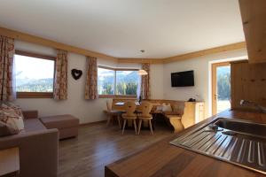 a living room with a couch and a table and chairs at Apartments DAMONT in Santa Cristina Gherdëina