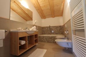 a bathroom with a sink and a toilet and a tub at Apartments DAMONT in Santa Cristina Gherdëina +44 photos
