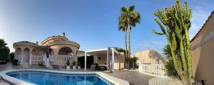 a house with a swimming pool and a palm tree at Casa Kiga in Ciudad Quesada