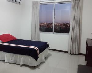 a bedroom with a bed and a large window at Elegant apartment for rent, day, week, month in Santa Cruz de la Sierra +14 photos