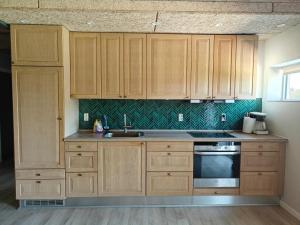 a kitchen with wooden cabinets and a sink at Sønderbygaard B&B in Årre