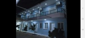 a blue building with a balcony on top of it at Manas Rooms in Dhërmi +19 photos