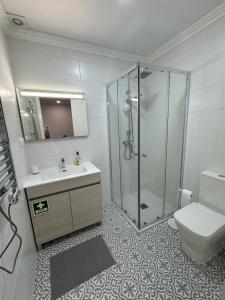 a bathroom with a shower and a sink and a toilet at Ponto de vista in Angra do Heroísmo