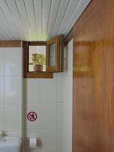 a bathroom with a toilet and a window with a plant at Studios Galanis in Afitos +23 photos