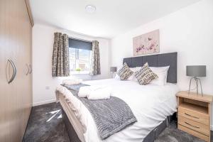 a bedroom with a large white bed and a window at Super Prime Luxury 4 Bedroom Detached Home By Tba in Fife