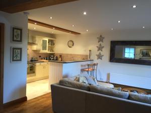 a living room with a couch and a kitchen at The Apple Shed in Farmborough