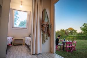 a man sitting at a table in a house at Camping Onlycamp La Potinière in Écueillé