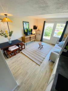 a living room with a couch and a table at Charmant T2 4 à 5 personnes in Arzon +9 photos