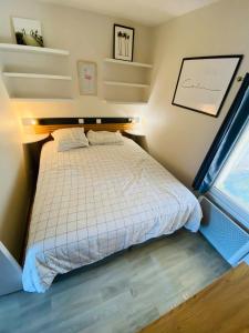 a small bedroom with a bed and a window at Charmant appartement, proche mer avec piscine pour 4 personnes in Arzon +12 photos
