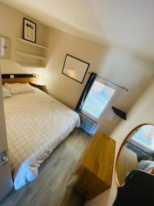 a bedroom with a bed and a window and a mirror at Charmant T2 4 à 5 personnes in Arzon