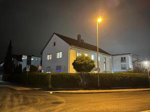 a white house with a street light on a street at Gästezimmer Fateev 4 in Senden