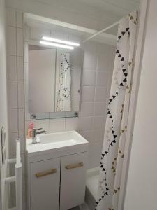 un bagno bianco con lavandino e specchio di Studio 3 couchages vue mer a Châtelaillon-Plage