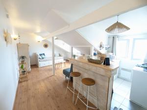 una cucina e un soggiorno con bancone e sgabelli di Studio 3 couchages vue mer a Châtelaillon-Plage