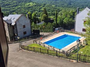 a swimming pool in front of a house with a mountain at El Puyal de Benas in Benasque