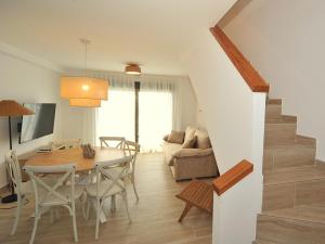 a dining room and living room with a table and chairs at Orange Park Duplex Atico Premium in Benicàssim