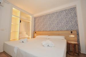 a white bedroom with two white towels on a bed at Orange Park Duplex Atico Premium in Benicàssim +34 photos