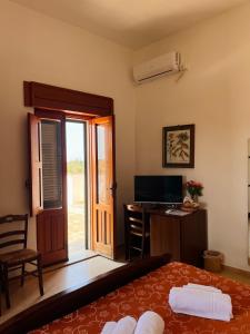 a room with a bed and a desk with a television at B&B Casale Spisari in Galatone
