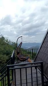 a chair sitting on top of a table on a balcony at Hilltop Heaven Cabanas 