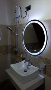 a bathroom with a sink and a mirror at Hilltop Heaven Cabanas 