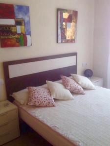 ein Schlafzimmer mit einem weißen Bett mit Kissen darauf in der Unterkunft Playa Sol Apartment in Denia