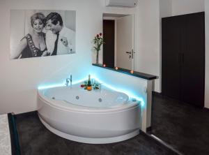 ein Badezimmer mit einer Badewanne mit einem Bild von einem Paar in der Unterkunft Good Life Via Veneto in Rom