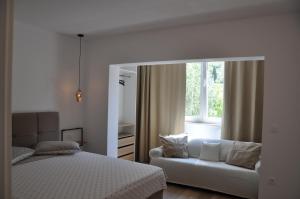 a bedroom with a bed and a couch and a window at Apartments Gabriela in Drasnice