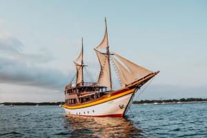 a boat sitting in the water on the water at Behike Luxury Phinisi in Labuan Bajo