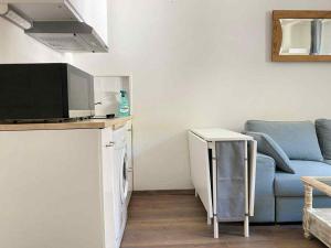 a living room with a couch and a tv at Studio Bareges Le Rioulet 1 in Barèges
