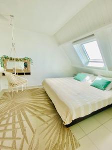 a bedroom with a large bed and a swing at Duplex-SeaYa-CentreVille&Marina in Marigot