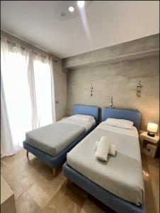 a bedroom with two beds and a window at Bianco Mare Villa in Otranto +19 photos