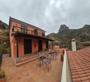 a patio with chairs and tables in front of a house at Tamahuche Hotel Rural in Vallehermoso