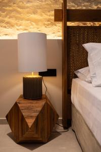 a lamp on a wooden table next to a bed at Madonna del Mare City in Chania
