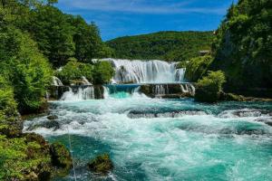 a waterfall in the middle of a river at Apartman Leon in Bihać