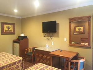 a hotel room with a bed and a tv on the wall at Beverly Inn in Los Angeles +30 photos