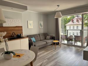 a living room with a couch and a table at Apartament Cesarski Agnes- bezpłatny parking- Resort Cesarskie Ogrody in Świnoujście