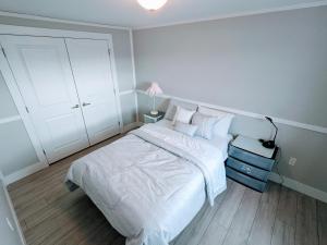 a bedroom with a bed with white sheets and pillows at 3 bedroom 1 bathroom entire house in Glace Bay