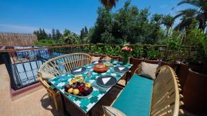 a table with a bowl of fruit on a balcony at Riad 2 Ksour Marrakesh in Marrakesh