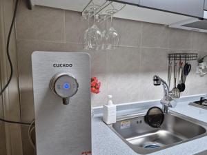 eine Küche mit einem Edelstahlkühlschrank und einer Spüle in der Unterkunft 잠실역 근처 가족숙소 더하리하우스 in Seoul + 28 Fotos