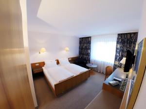 a hotel room with a bed and a television at Hotel Maack in Seevetal