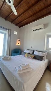 a large white bed with two towels on it at Myconian Villa -7 min Chora - center - 130sqm - 4people - 2 rooms - Secured Free Parking,- Elenas Hospitality - in Mýkonos City